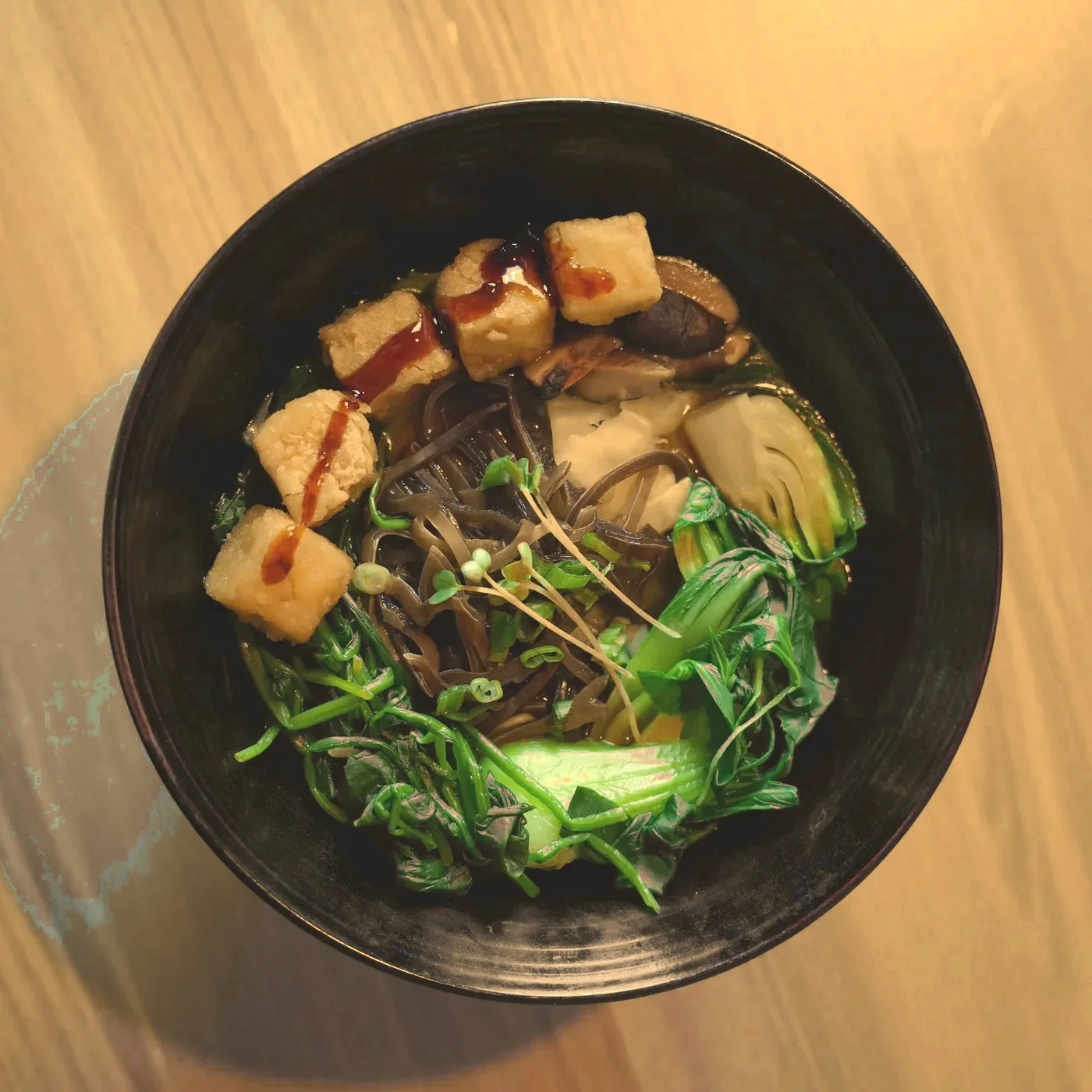 Vegetable ramen with glazed tofu, bok choy and greens, seen from above