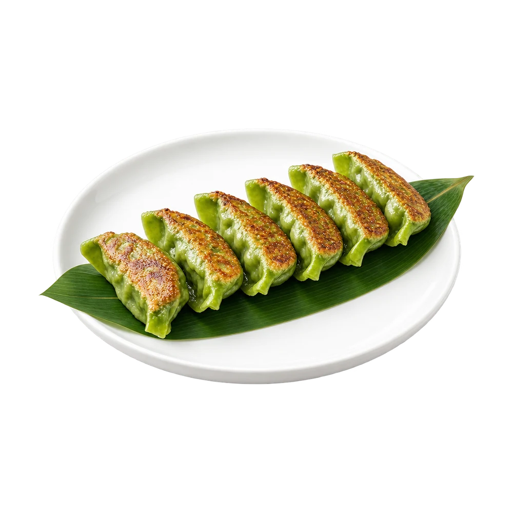 Six pan fried vegetable gyoza on a bamboo leaf