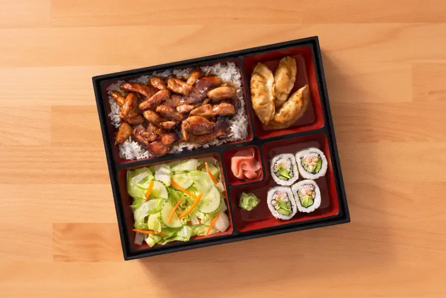 Chicken Bento box with salad, gyoza, California Sushi Rolls
