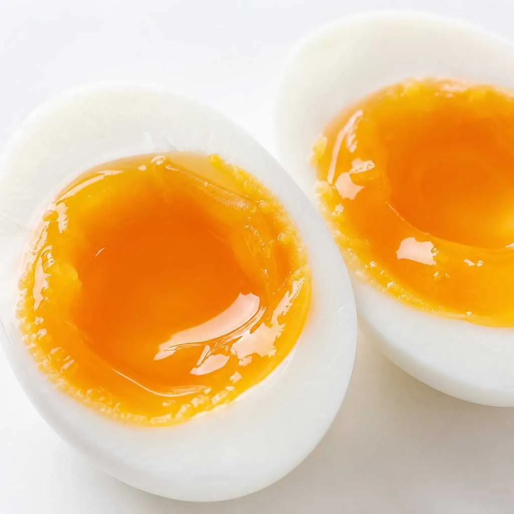 Cross-section of a perfectly cooked soft-boiled egg revealing the jammy, golden yolk center