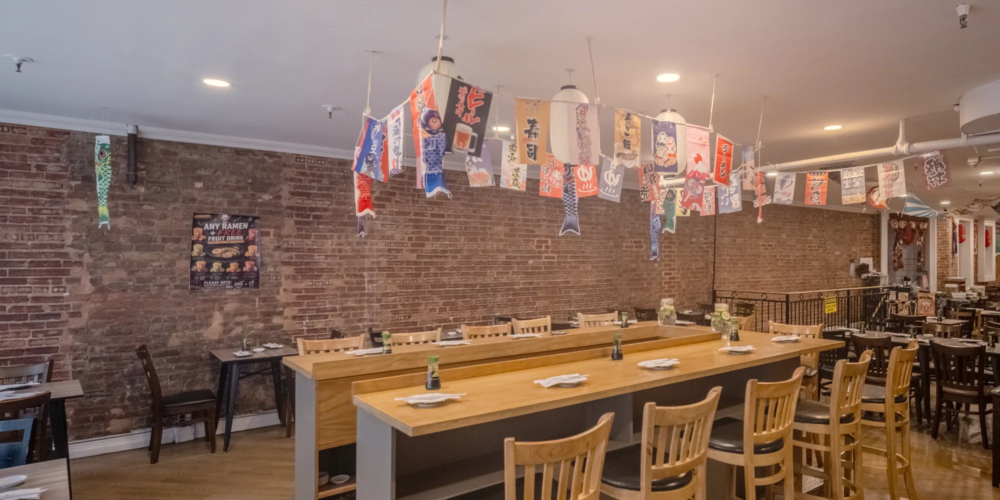 Long wooden tables under paper lanterns and Japanese banners in the Zen dining room