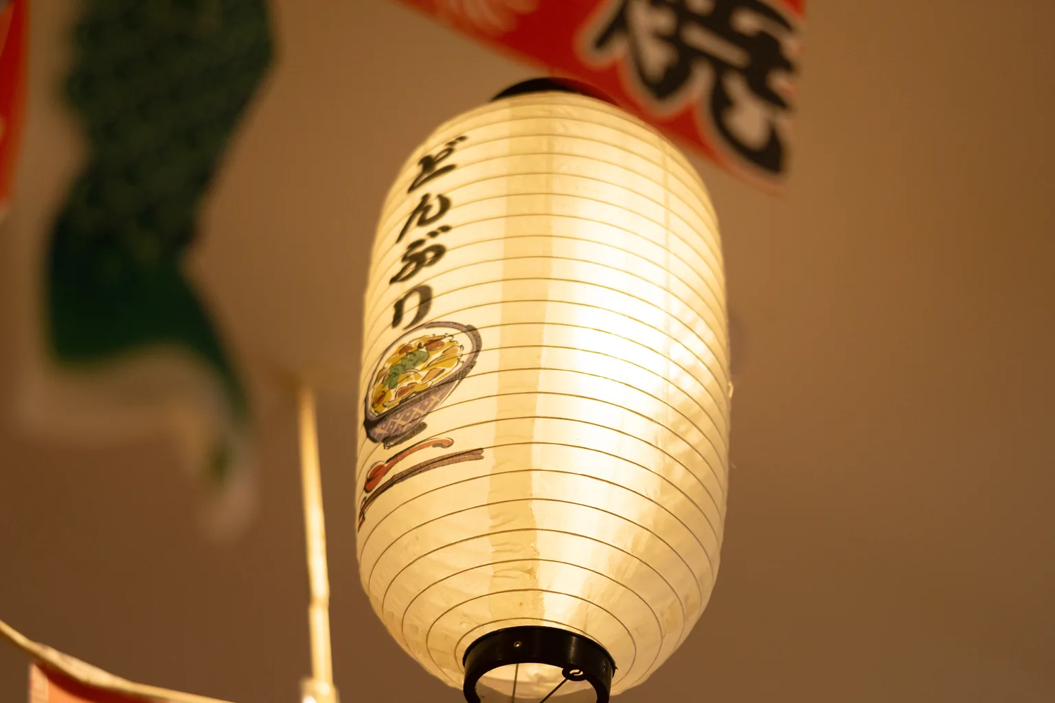 A glowing paper lantern among hanging banners